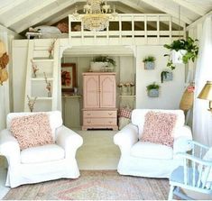 two white chairs and a pink cabinet in a room with wooden beams on the ceiling