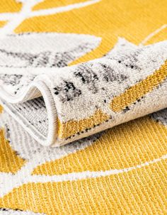 a yellow and white rug with an interesting design on the bottom half, laying on top of it