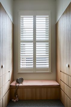 an empty room with wooden cabinets and a window that has blinds on the windowsill