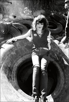 a woman riding on the back of a skateboard over an open manhole hole