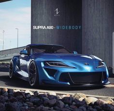 a blue sports car parked in front of a tall building with the words supra also wide body on it