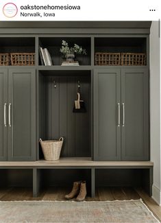 an entryway with gray cupboards and baskets on the top shelf, along with a rug