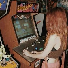 a woman playing a video game in front of a wall