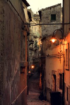 an alley way with old buildings and street lights