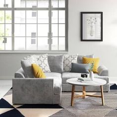 a living room with a gray couch and yellow pillows