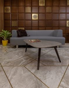 a couch and table in a room with wood paneling on the wall behind it