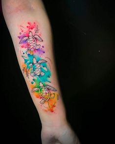 a person with a colorful tattoo on their arm and wrist, holding onto a black background