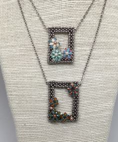 two necklaces with beads on top of each other and one has a flower in the middle