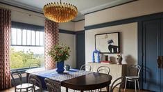 a dining room with blue walls and wooden floors