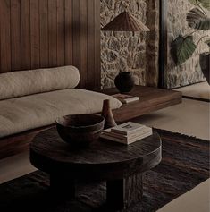 a living room filled with furniture and a stone wall next to a wooden table on top of a rug