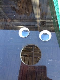 an upside down window with two round windows and one hole in the glass that has been cut out