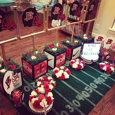 a football themed party with red and white flowers on the table, decorated by fans