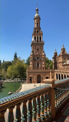 a tall tower with a clock on it's side next to a body of water