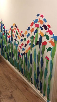 the wall is decorated with colorful fish and streamers on it, along with wood flooring