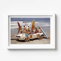 a group of people sitting on top of a car with surfboards