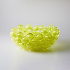 a bowl filled with green grapes on top of a table