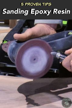 a person using a sanding machine to polish the surface on top of a piece of wood