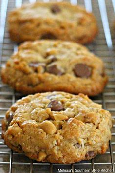 three cookies cooling on a wire rack with one cookie in the foreground and two chocolate chip cookies in the background