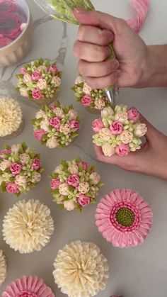 someone is decorating cupcakes with pink and green flowers