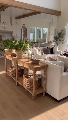 a living room filled with white furniture and lots of wood flooring on top of it