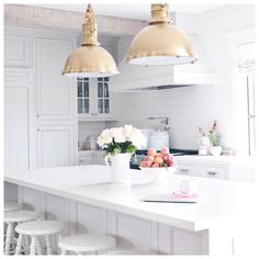 an instagram page with two pendant lights above the kitchen island and flowers on the counter