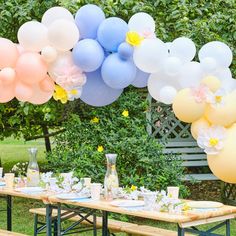 a long table with balloons and flowers on it