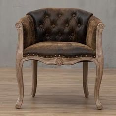 an old fashioned chair with leather upholstered on the back and armrests