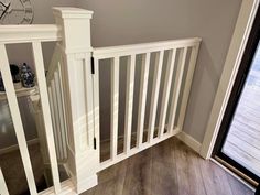 an empty room with wooden floors and white railings