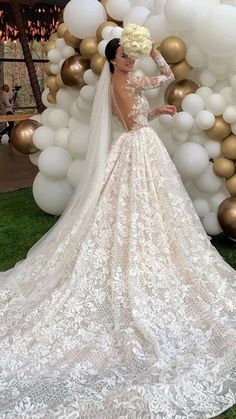 a woman in a wedding dress standing next to balloons