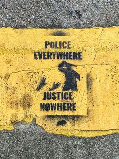 a yellow and black sign that says police everywhere, justice nowhere on the sidewalk next to it