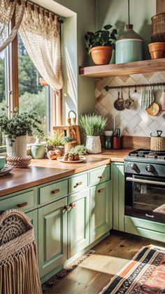 a kitchen filled with lots of green cupboards and counter top next to a window