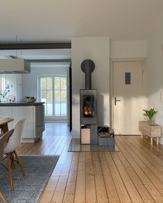 a living room filled with furniture and a fire place in the middle of a kitchen