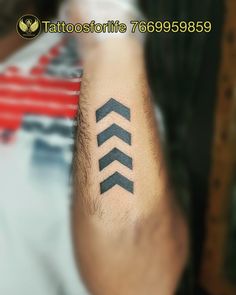 a man with a tattoo on his arm that has three arrows in the middle of it