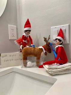 two elfs sitting on top of a bathroom counter