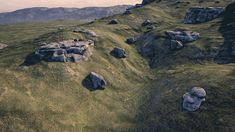 an aerial view of rocks and grass on a hill side with mountains in the background