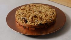 a cake sitting on top of a metal plate covered in crumbs and oatmeal