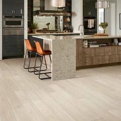 a large kitchen with wooden floors and gray cabinets