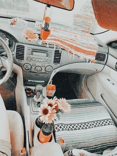 the interior of a car with flowers in vases on the dash board and sunroof