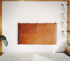 a brown leather wall hanging over a white rug