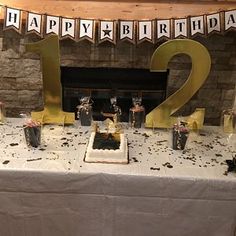 a birthday cake with candles and decorations on a table in front of a fire place