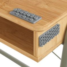 a close up of a wooden table with a remote control on the top and bottom