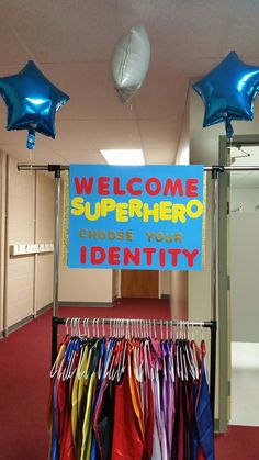 there is a sign that says welcome to superheros choose your identity and blue balloons