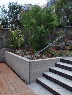 there is a planter on the side of this deck that has stairs leading up to it