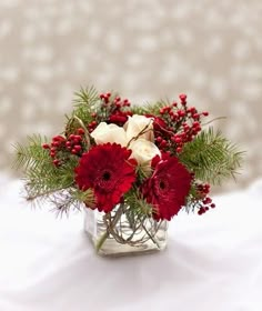 a glass vase filled with red and white flowers