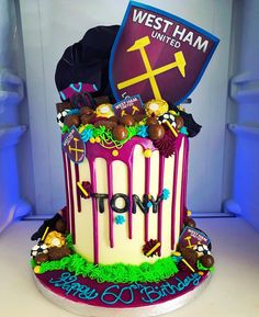 a birthday cake decorated with decorations and a shield on top that says west ham united