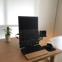 a laptop computer sitting on top of a wooden desk next to a mouse and keyboard