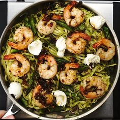 a pan filled with pasta and shrimp on top of a stove