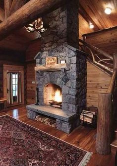 a living room filled with furniture and a fire place in the middle of a wooden floor