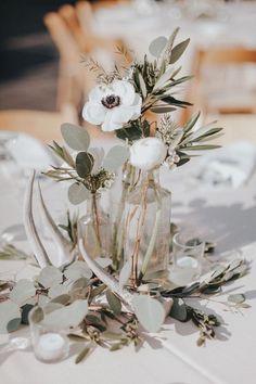 flowers and greenery are in vases on the table at a wedding breakfasteon