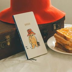 a piece of cake sitting on top of a white plate next to a red hat